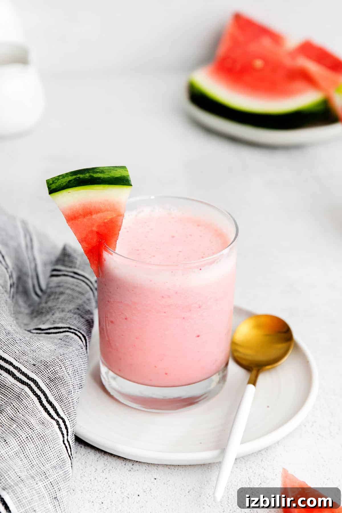 Refreshing Watermelon Smoothie Recipe 2 A watermelon smoothie in a glass that is garnished with a fresh chunk of watermelon.