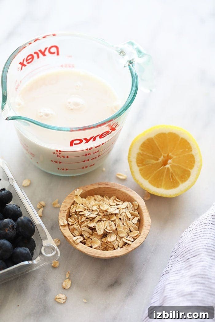 These fresh and flavorful Lemon Blueberry Baked Oatmeal Cups are a healthy breakfast idea made with whole grains. almond milk, rolled oats, lemon, and blueberries on countertop