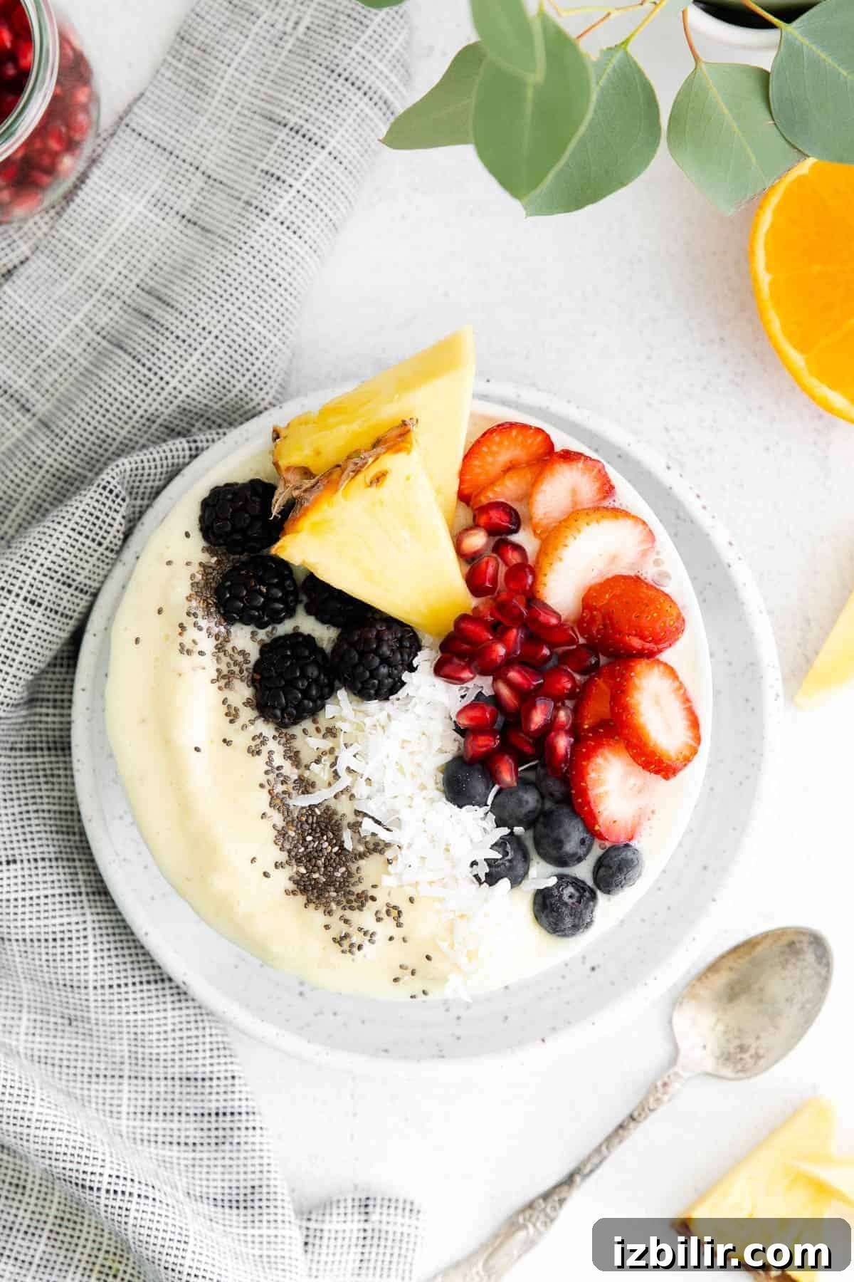 This easy pineapple smoothie recipe is made with frozen pineapple chunks, Greek yogurt, pineapple juice, and a banana. It tastes like tropical paradise! pineapple smoothie bowl with berries on top