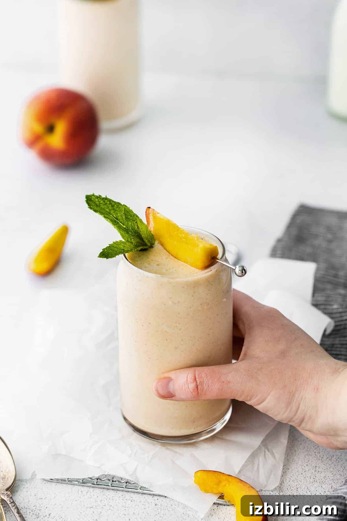 hand holding peach smoothie