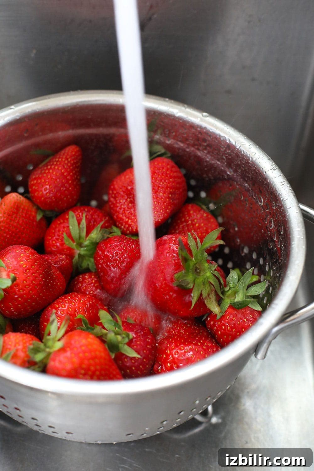 How to Freeze Strawberries Without Freezer Burn 4 Rinsing fresh strawberries with water.