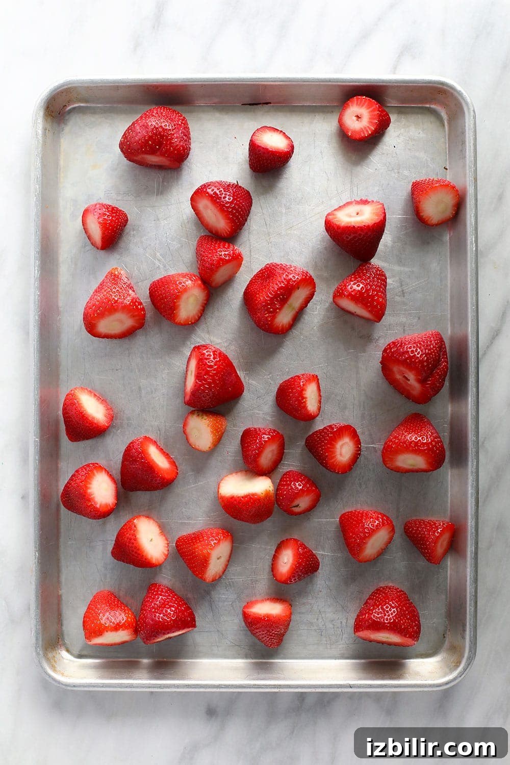 How to Freeze Strawberries Without Freezer Burn 5 Strawberries spread out on a baking sheet.
