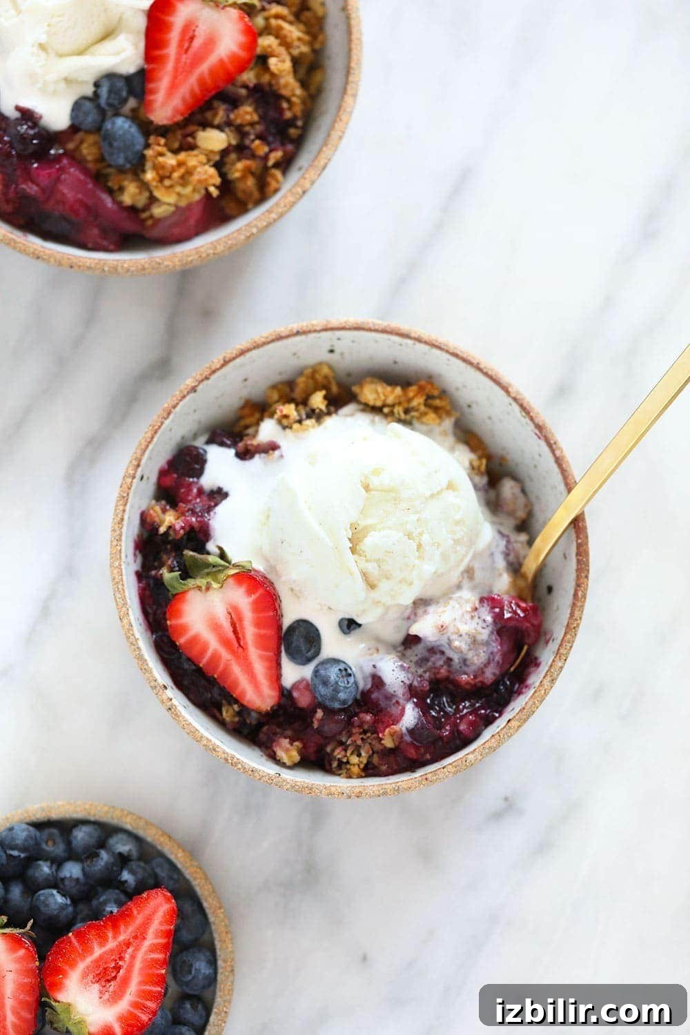 Delicious Berry Crumble made with 3 different kinds of berries and the most delicious crumble topping! berry crisp in bowl with ice cream on top
