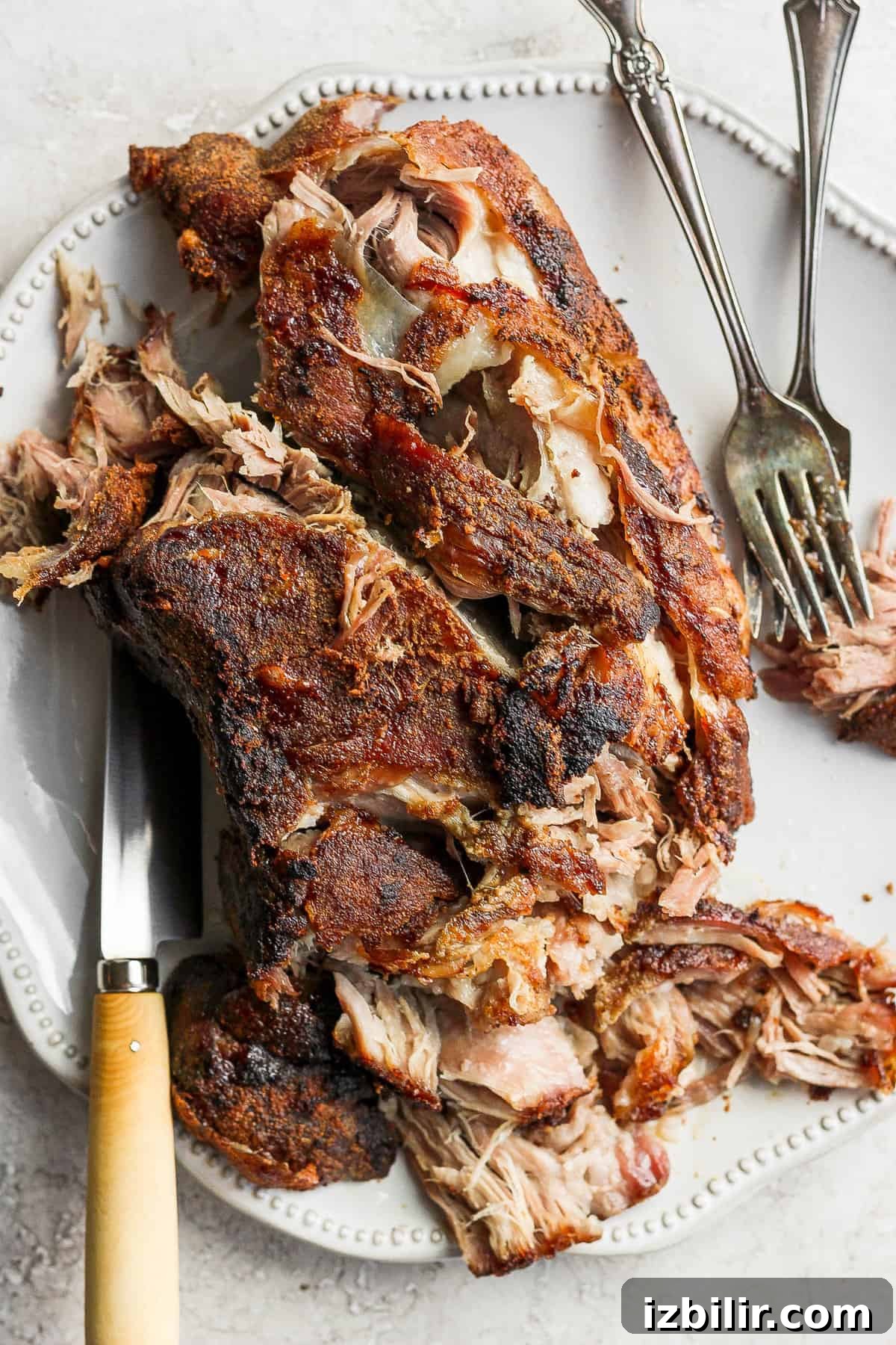 Slow-Roasted Pork Shoulder Recipe for Tender Pulled Pork 2 shredded pork on platter.