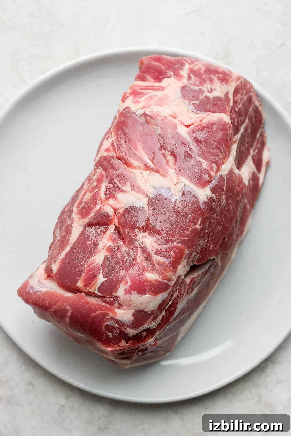 Slow-Roasted Pork Shoulder Recipe for Tender Pulled Pork 4 pork shoulder on plate.