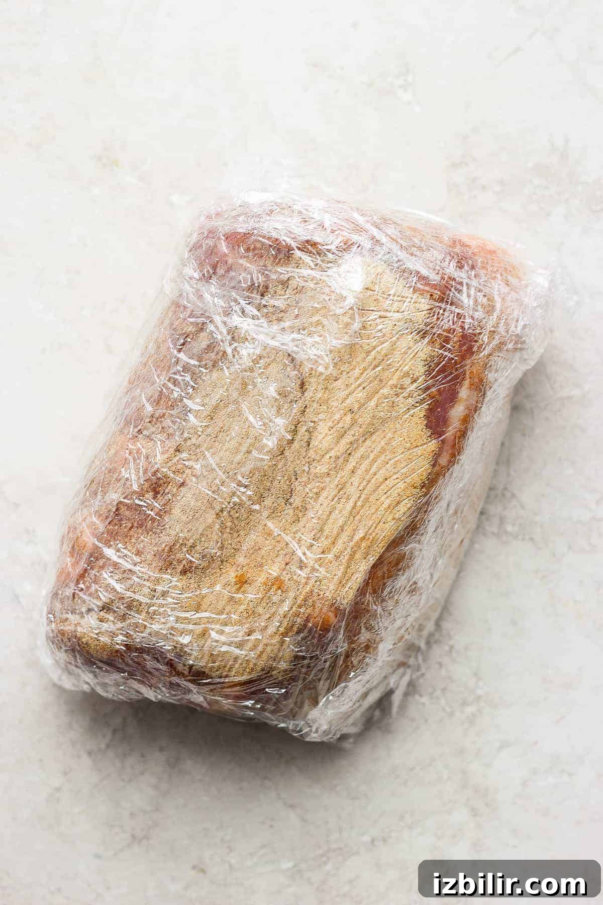 Slow-Roasted Pork Shoulder Recipe for Tender Pulled Pork 6 pork wrapped in plastic wrap.
