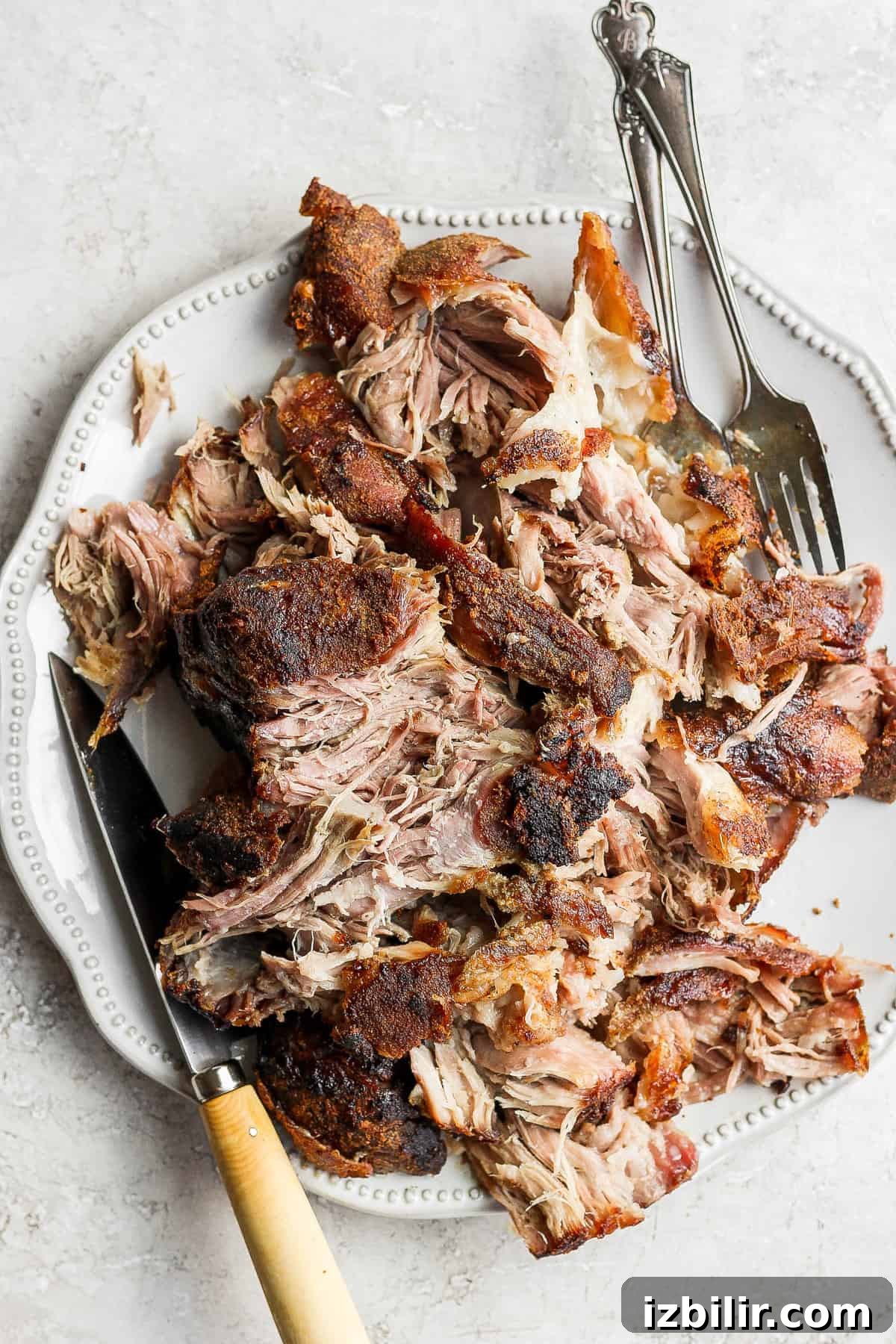 Slow-Roasted Pork Shoulder Recipe for Tender Pulled Pork 8 shredded pork on platter.