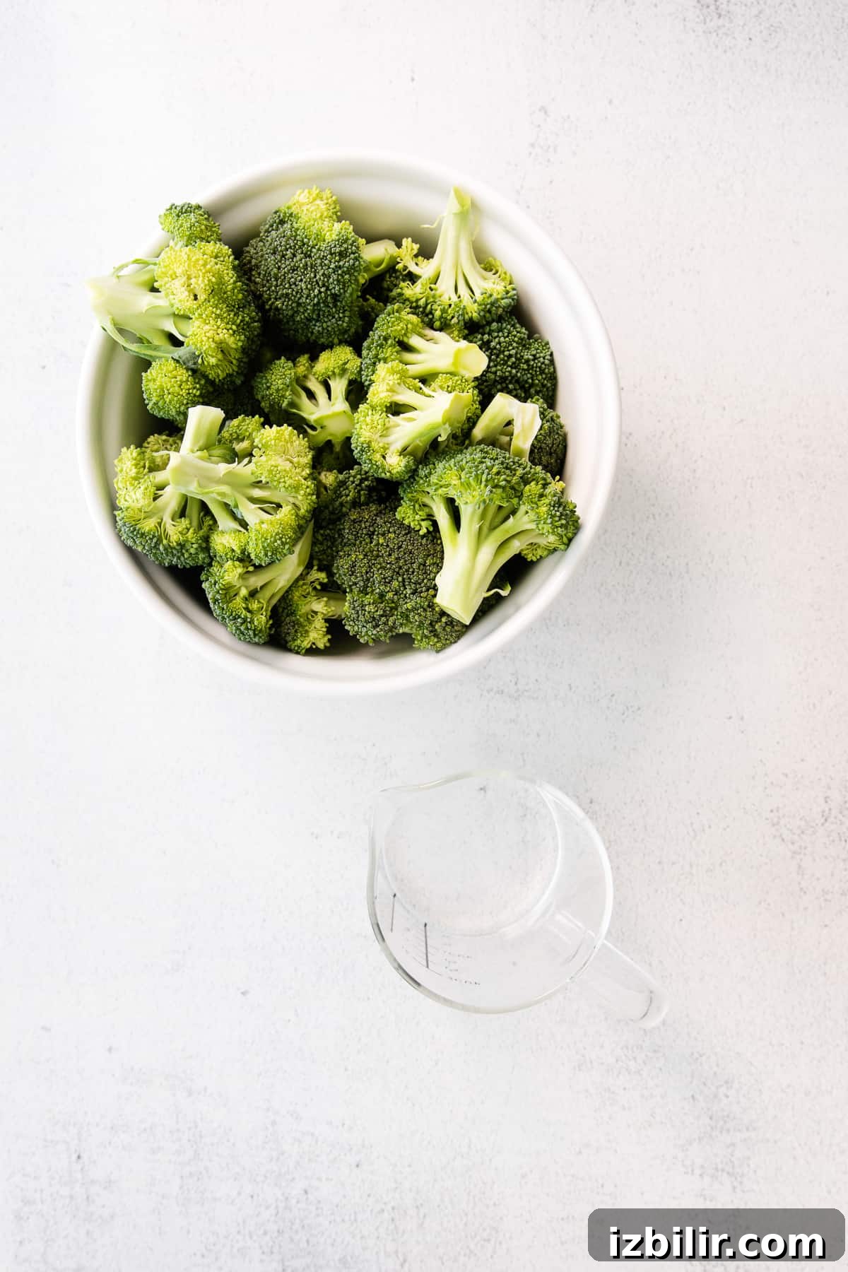Broccoli and water ready for steaming. broccoli in bowl and water in cup