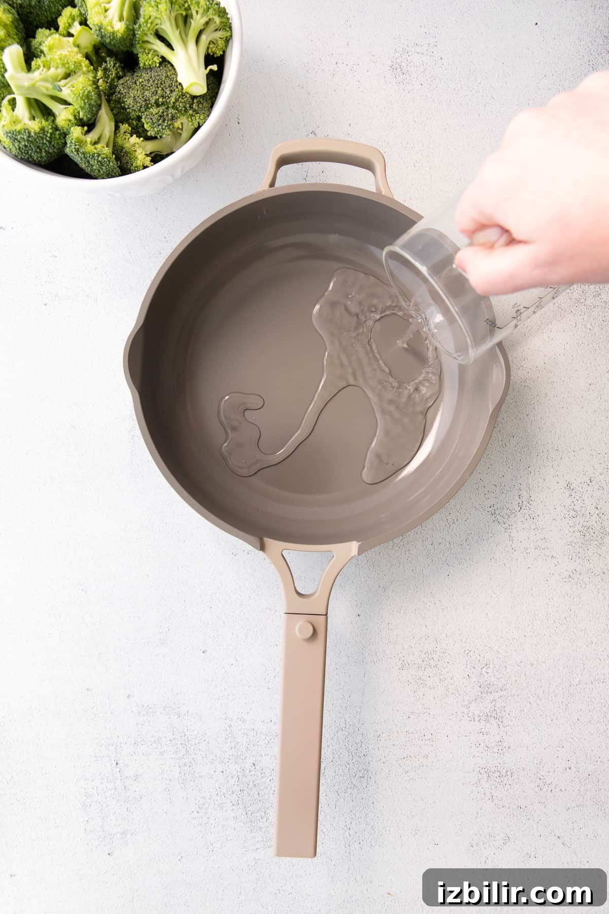 Pouring water for steaming broccoli. pouring water into pan