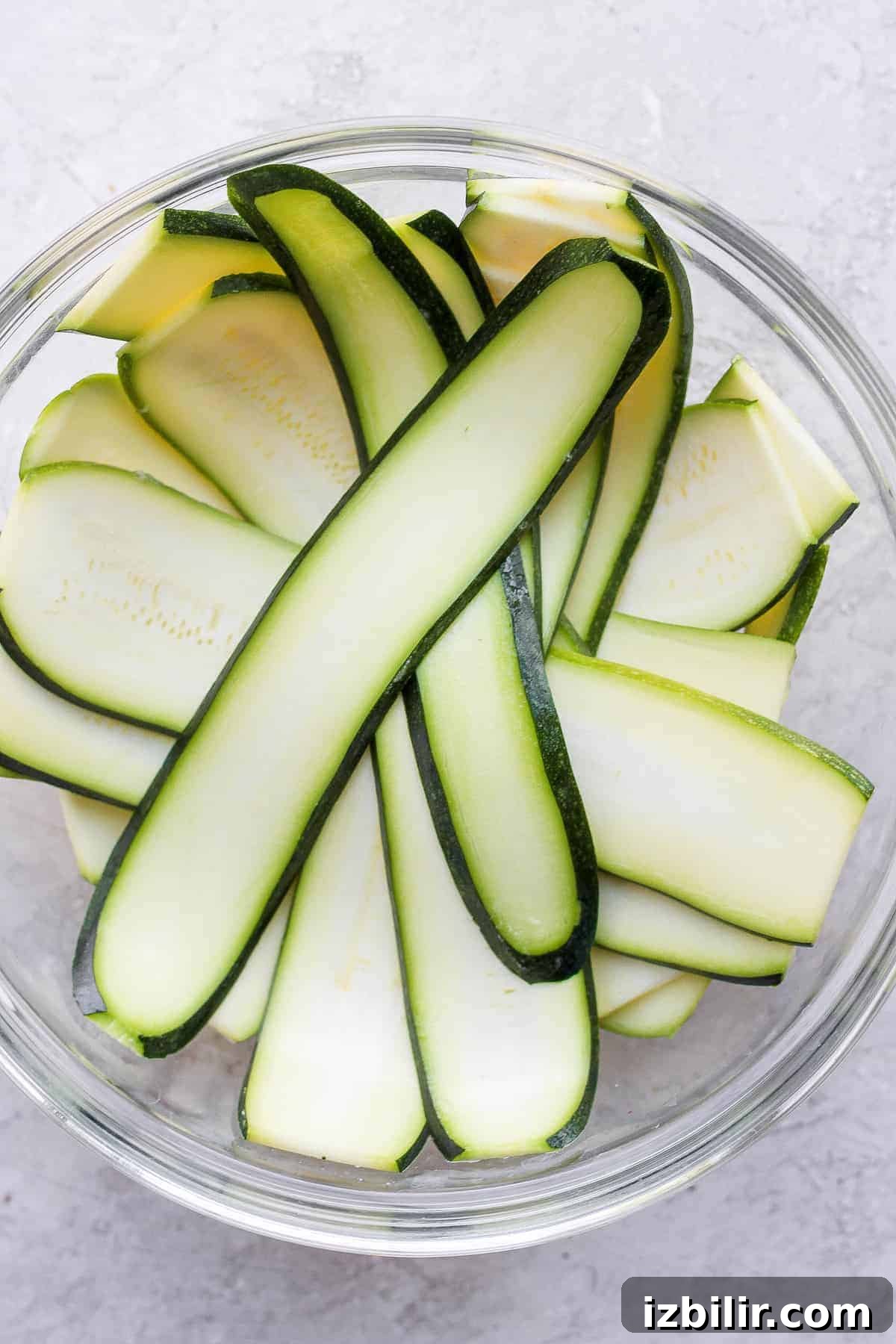 Zucchini thinly sliced in a bowl zucchini sliced by a mandolin in a bowl