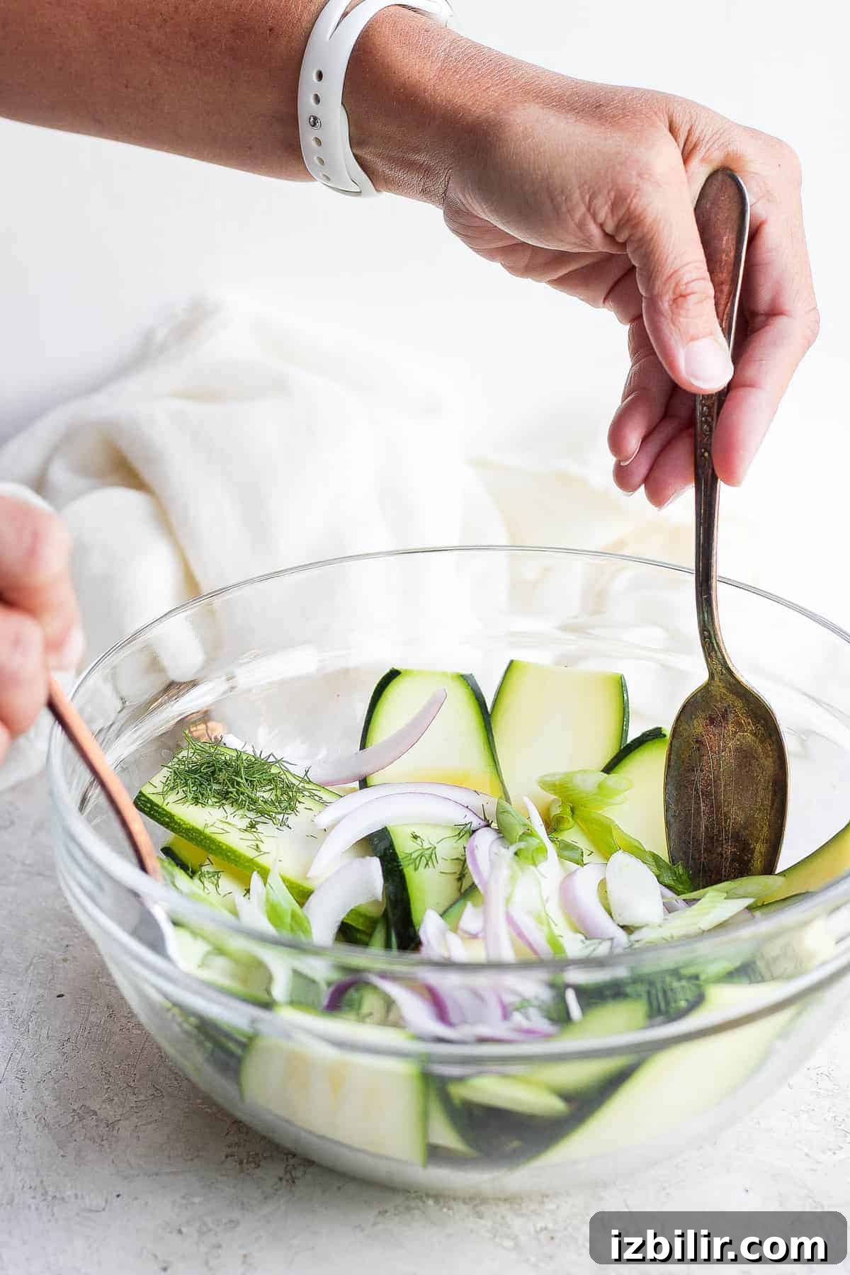 Tossing zucchini salad tossing zucchini salad ingredients together with spoons