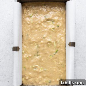 Moist Zucchini Bread with Cinnamon and Walnuts 9 A metal pan filled with food on top of a table.