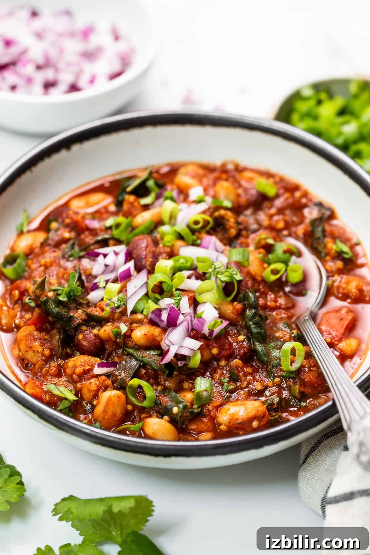 Nourishing quinoa chili with roasted red peppers and kale. bowl of quinoa chili.