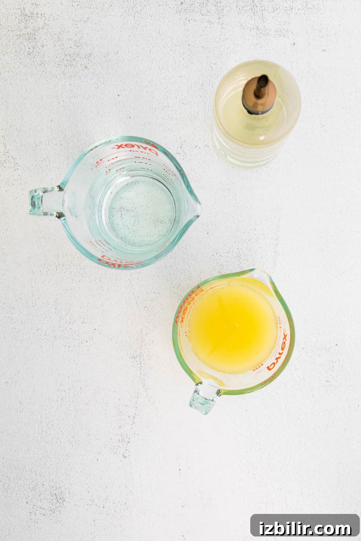Zesty Homemade Lemonade Recipe for Summer 3 Lemon juice, simple syrup, and water on a counter top.