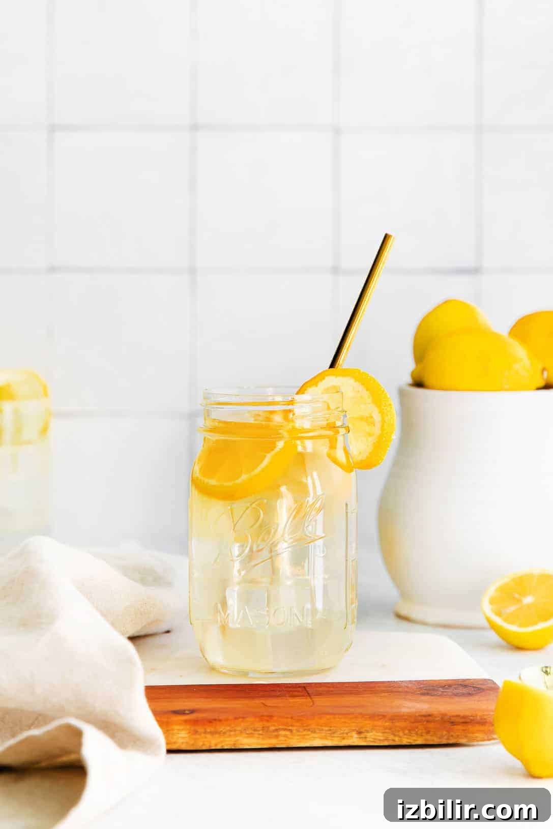 Zesty Homemade Lemonade Recipe for Summer 4 A jar of lemonade with a straw and lemon slices.