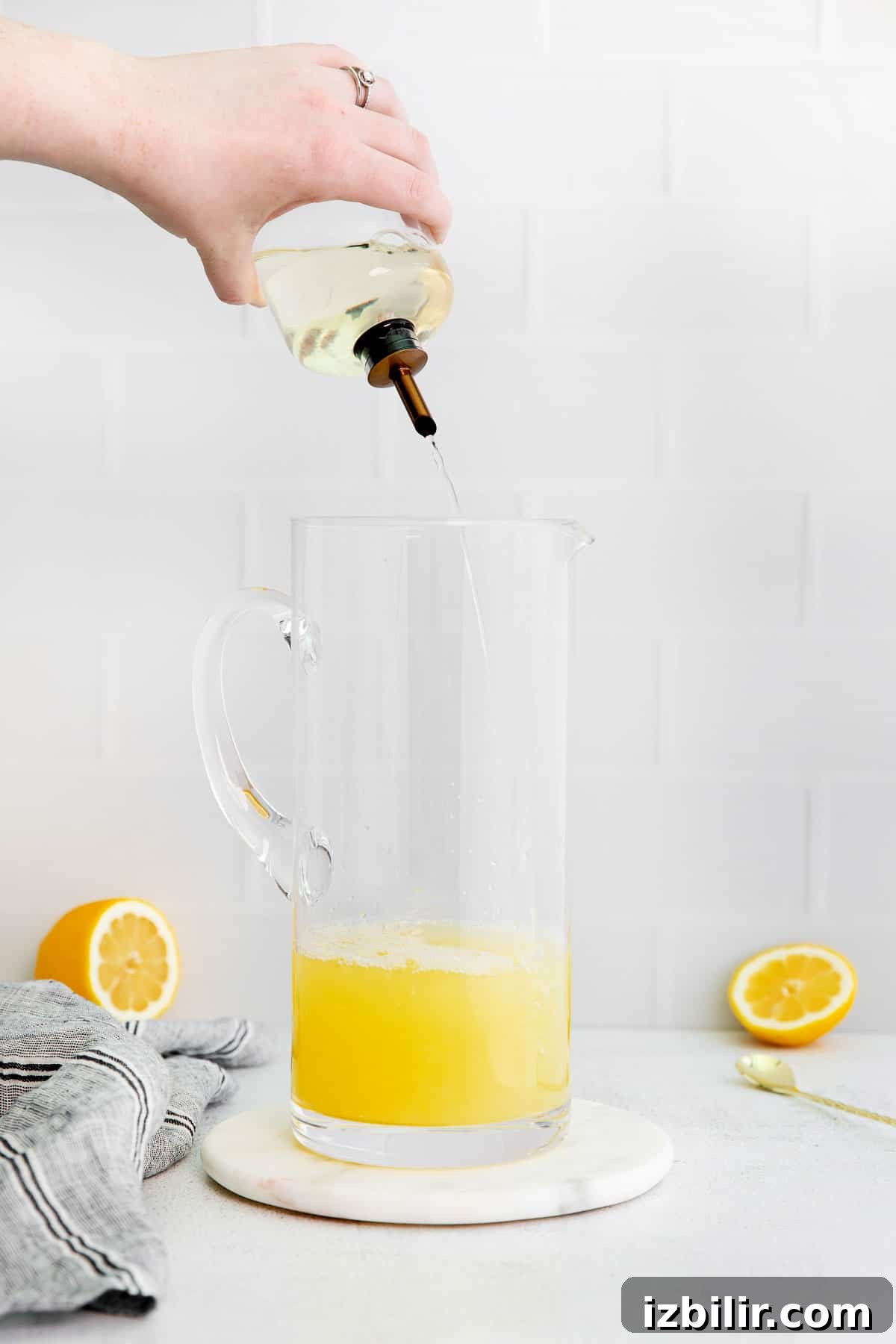 Zesty Homemade Lemonade Recipe for Summer 5 Pouring simple syrup into a pitcher.