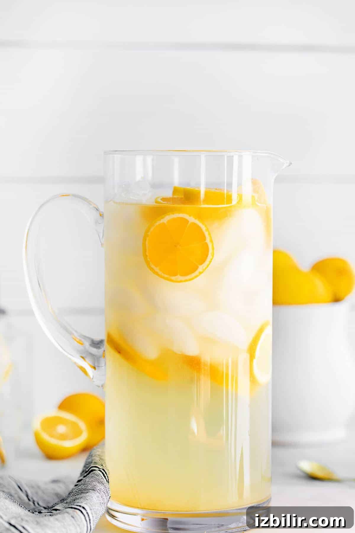 Zesty Homemade Lemonade Recipe for Summer 7 A pitcher of lemonade with ice and lemon slices floating in it.