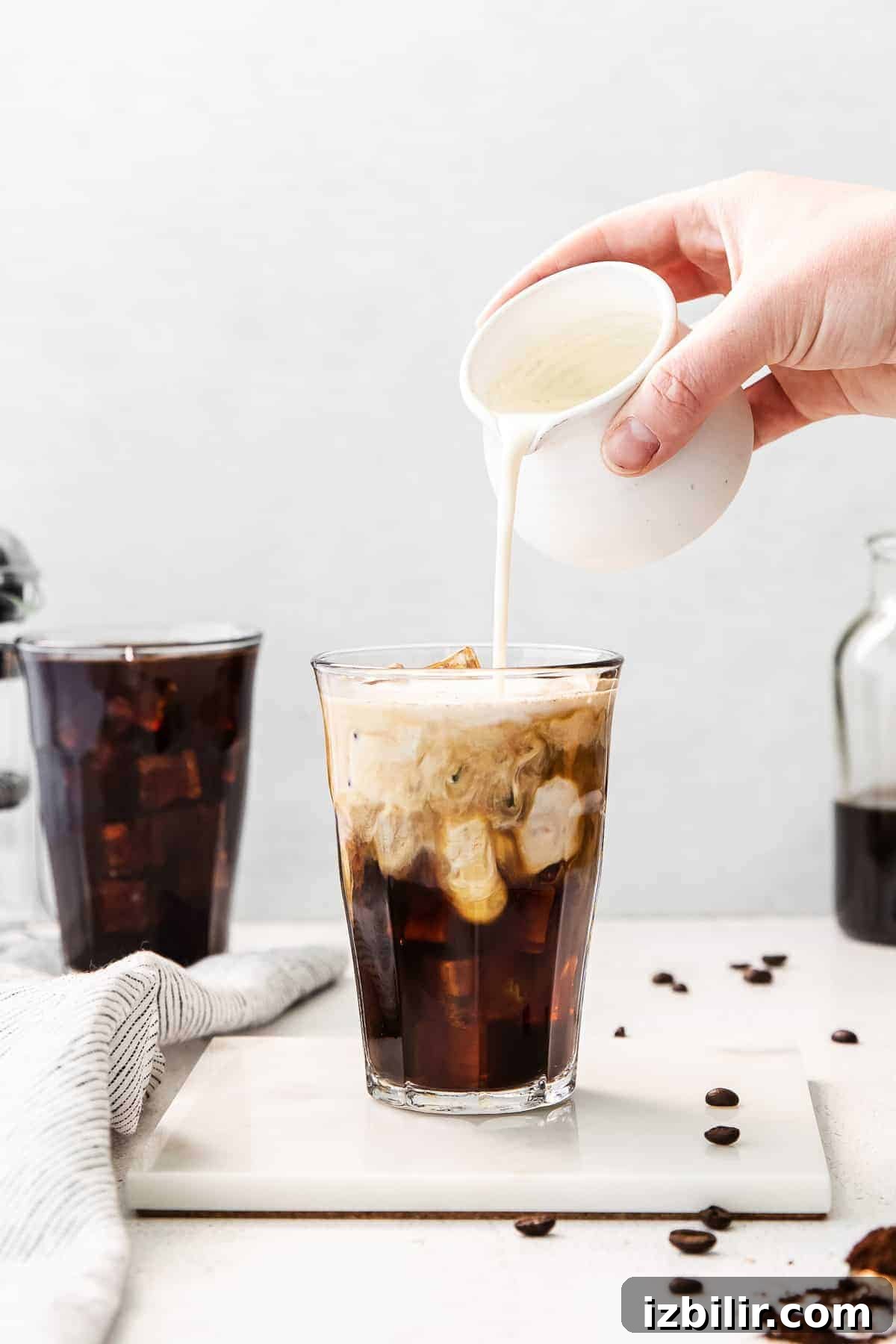 Cold Brew Coffee Recipe: Brew Smooth Coffee at Home 2 Pouring cream into cold brew coffee