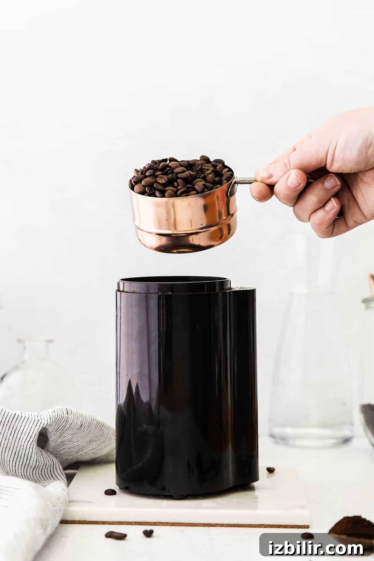 Cold Brew Coffee Recipe: Brew Smooth Coffee at Home 4 Pouring coffee beans into a coffee grinder.