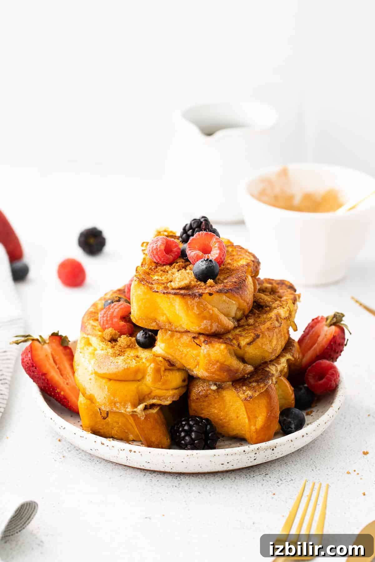 slices of french toast on a plate topped with fresh berries