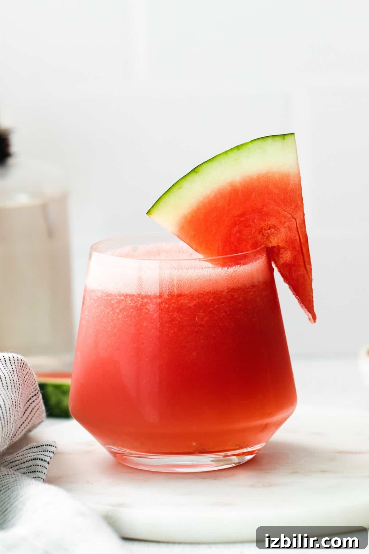 3 Wine Slushie Recipes for Summer Sipping 5 a watermelon drink in a glass with a slice of watermelon on.