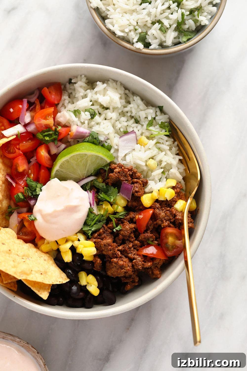 Whip up this filling beef taco bowl recipe for an incredible meal prep idea that's perfect for a work lunch or dinner at home! Taco bowl with ground beef and cilantro lime brown rice.