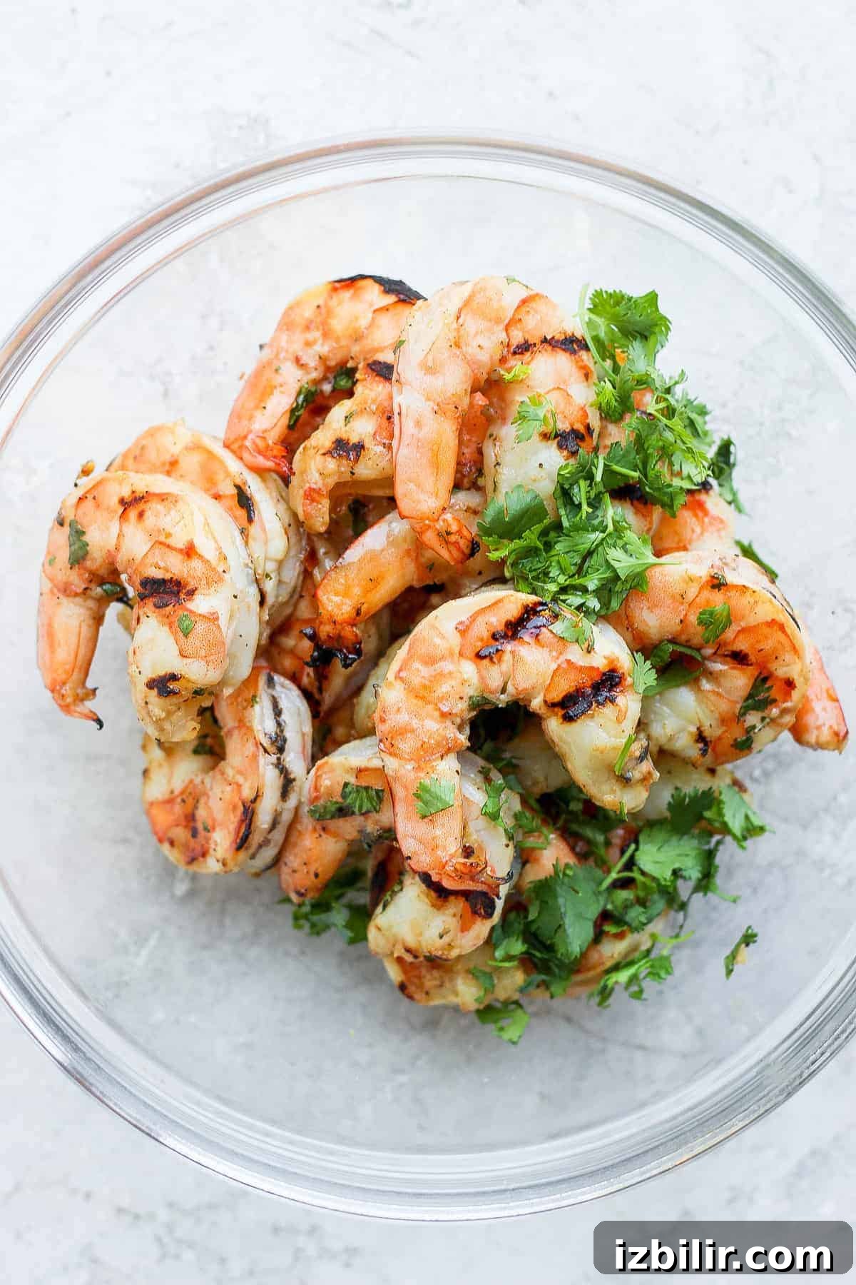 Grilled shrimp tossed with cilantro Grilled shrimp in a bowl topped with fresh chopped cilantro.