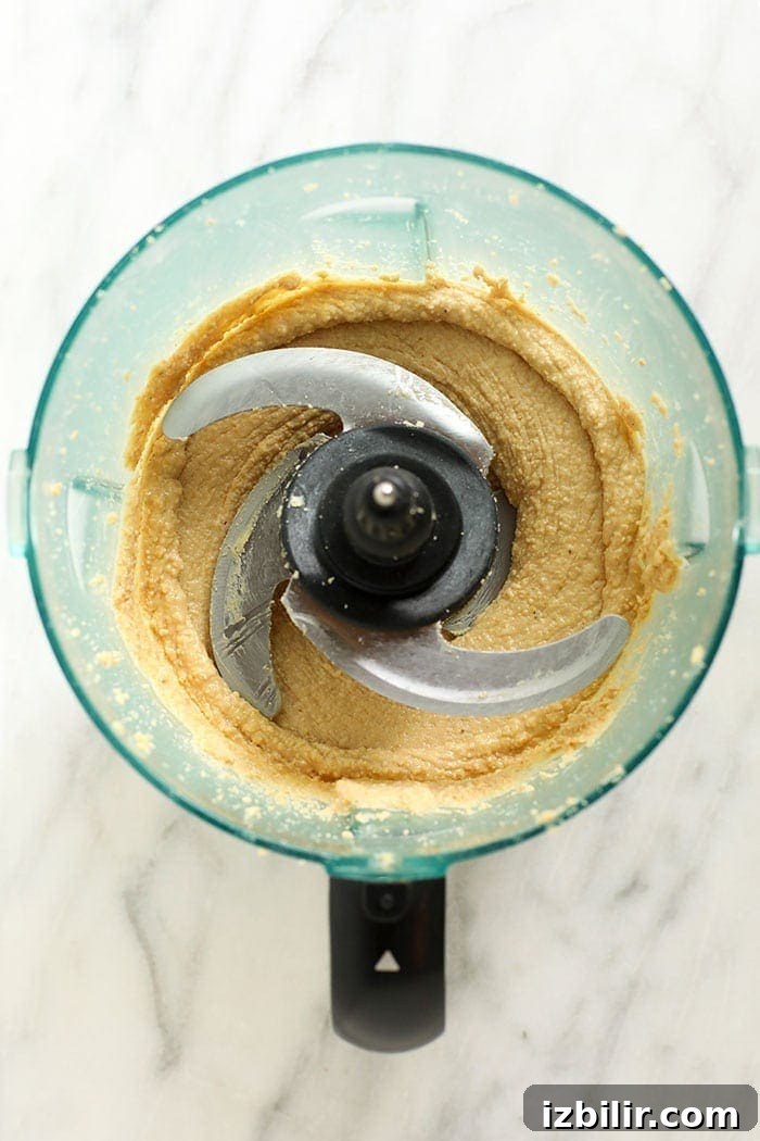 Cashews blending into cashew butter cashews partially blended in a food processor