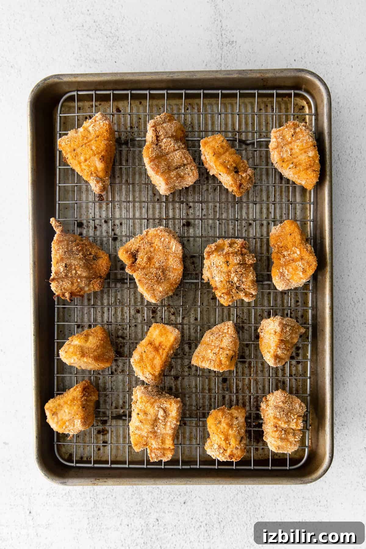 golden brown chicken nuggets on baking sheet