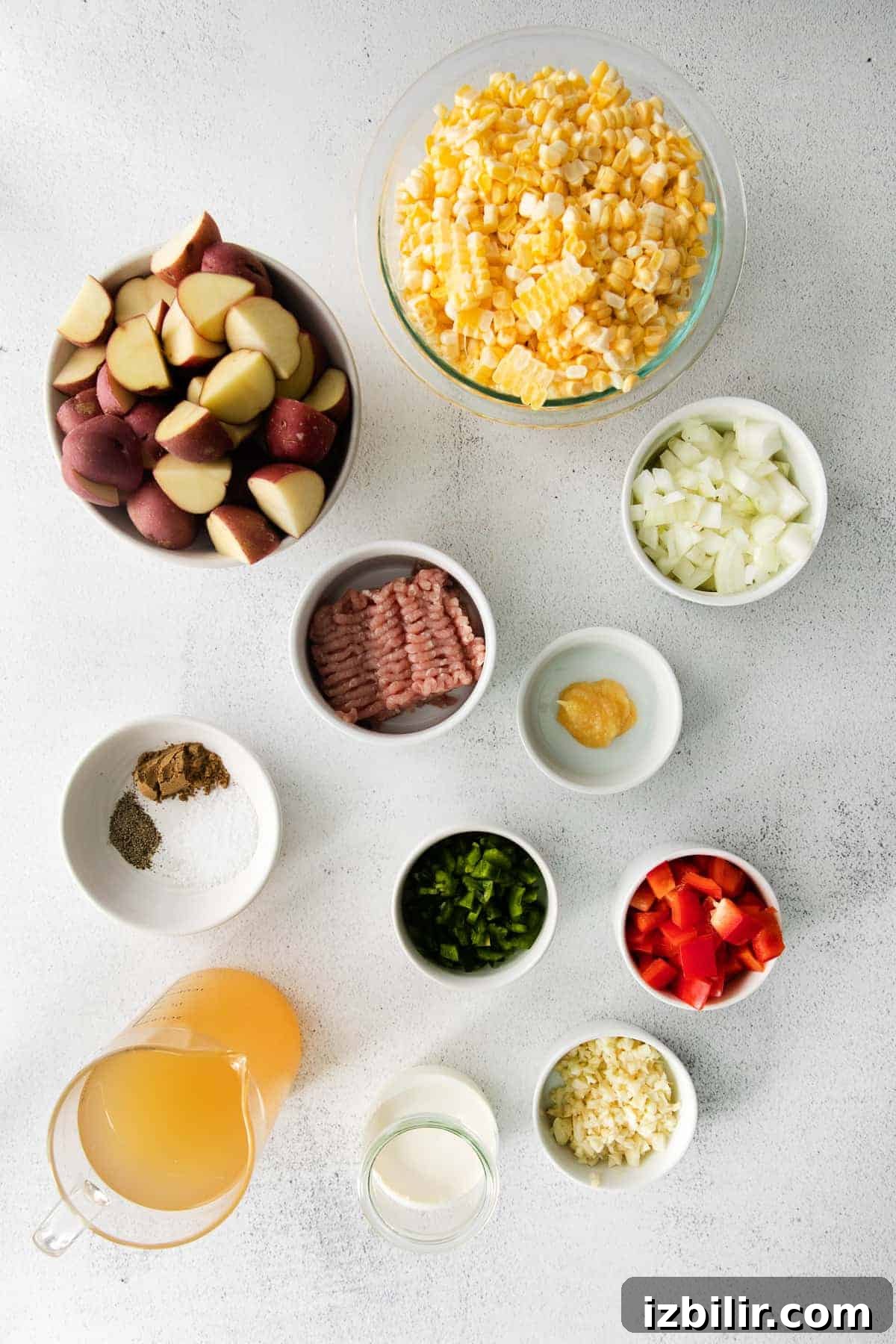A mouthwatering corn chowder made with fresh sweet corn, potatoes, ground pork, spices, and a splash of heavy cream. ingredients on counter