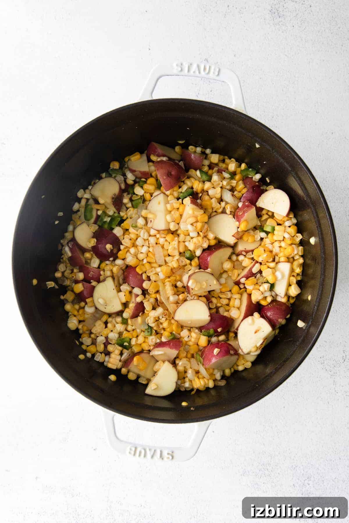 Fresh vegetables in a Dutch oven ready to become corn chowder. veggies in Dutch oven