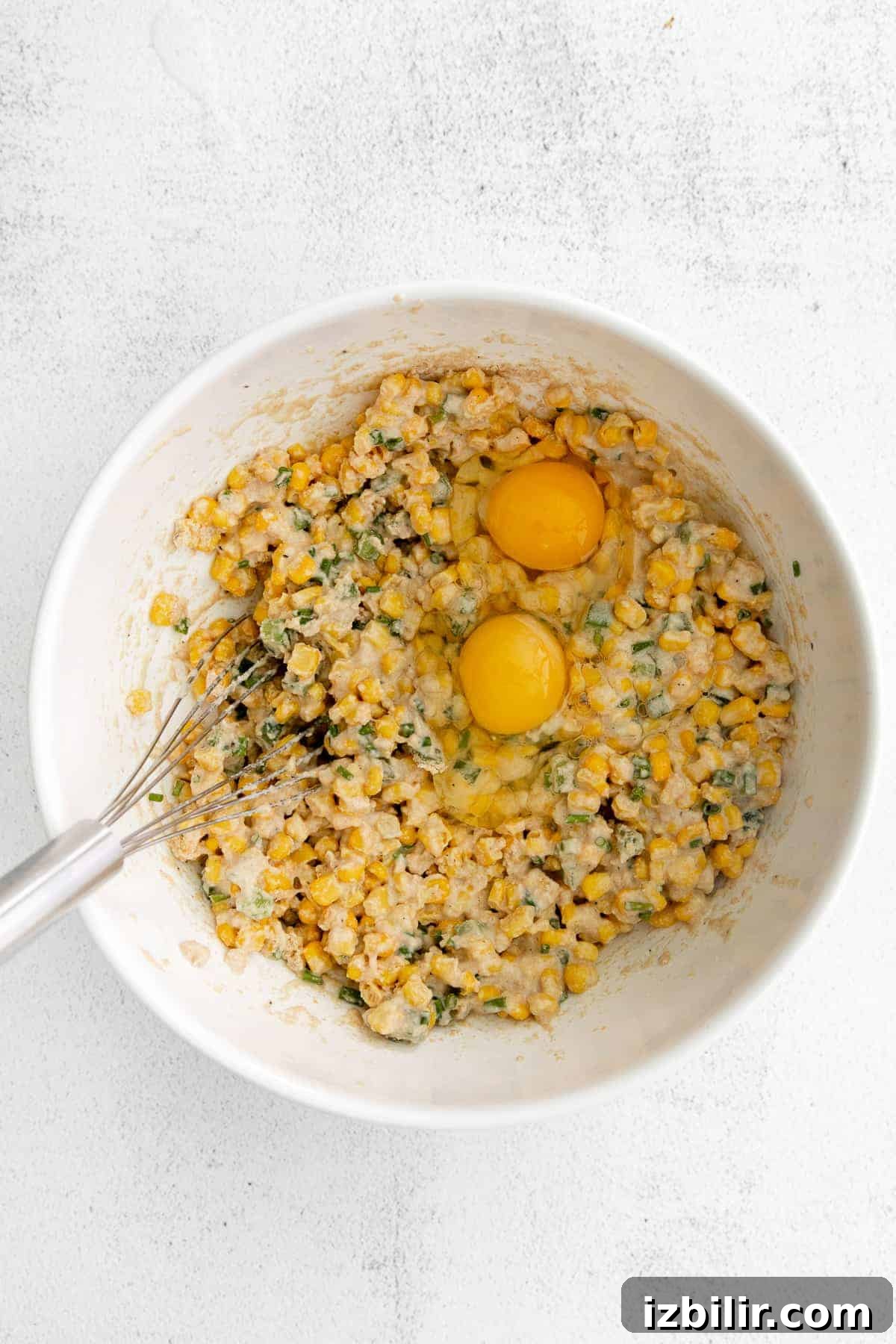 Corn fritter batter with whole eggs cracked on top. 