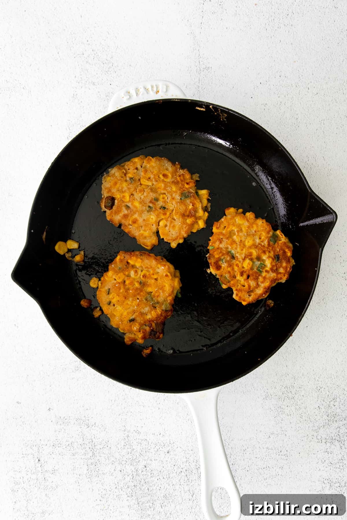 Crispy corn fritters in a cast iron pan. 
