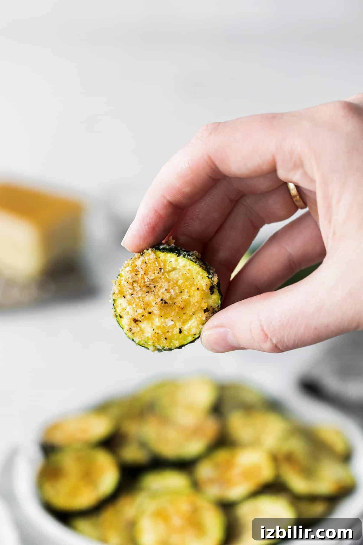slice of air fryer zucchini in someone's hand.