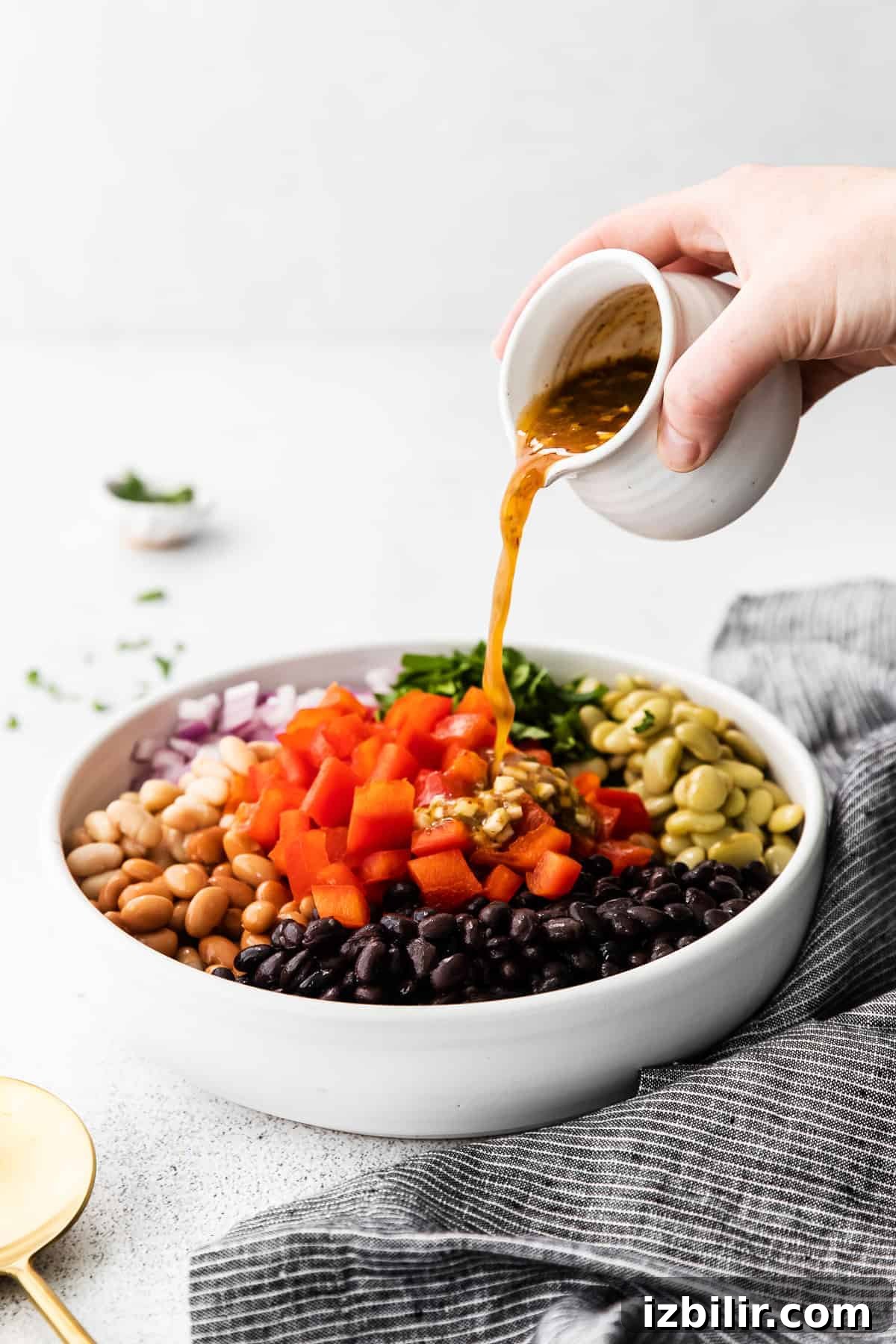 Pouring dressing over the bean salad.