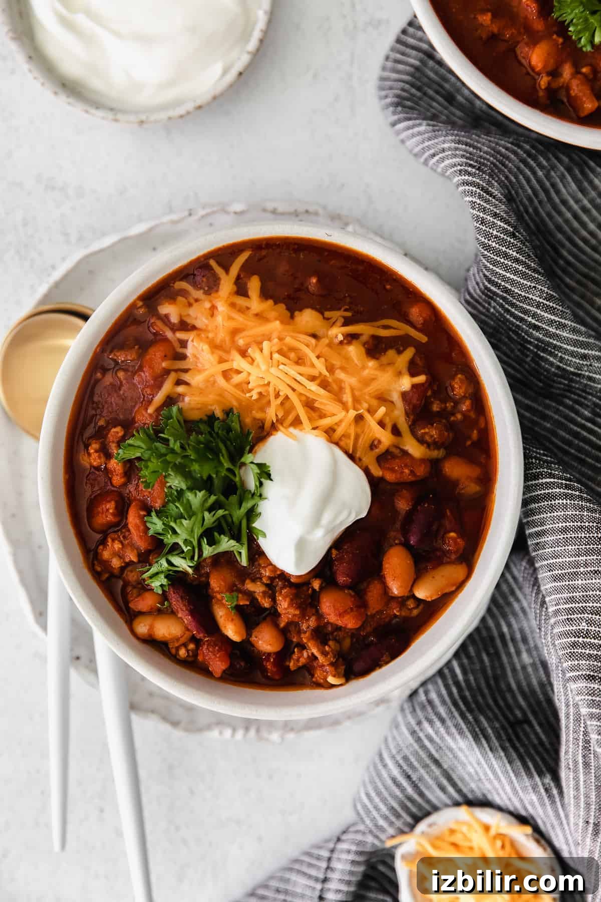 Hearty Instant Pot Beef and Bean Chili 2 instant pot chili topped with shredded cheese in a bowl.