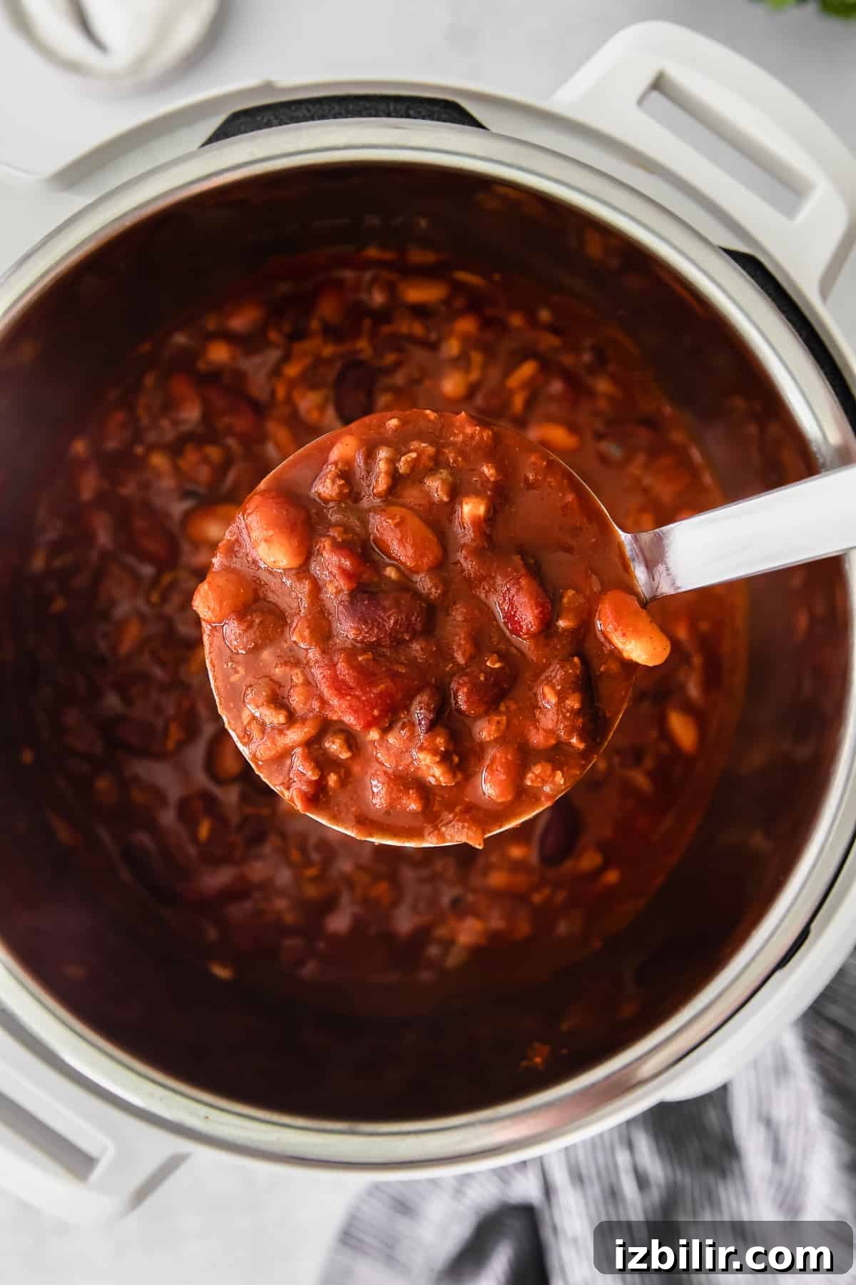 Hearty Instant Pot Beef and Bean Chili 6 instant pot chili filling a ladle.