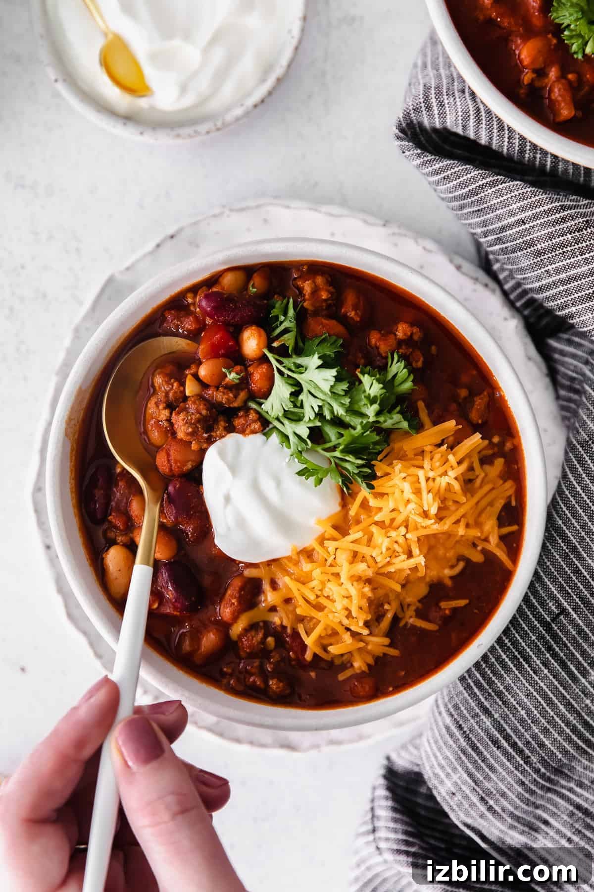 Hearty Instant Pot Beef and Bean Chili 7 instant pot chili in a bowl topped with shredded cheese greek yogurt and fresh parsley.