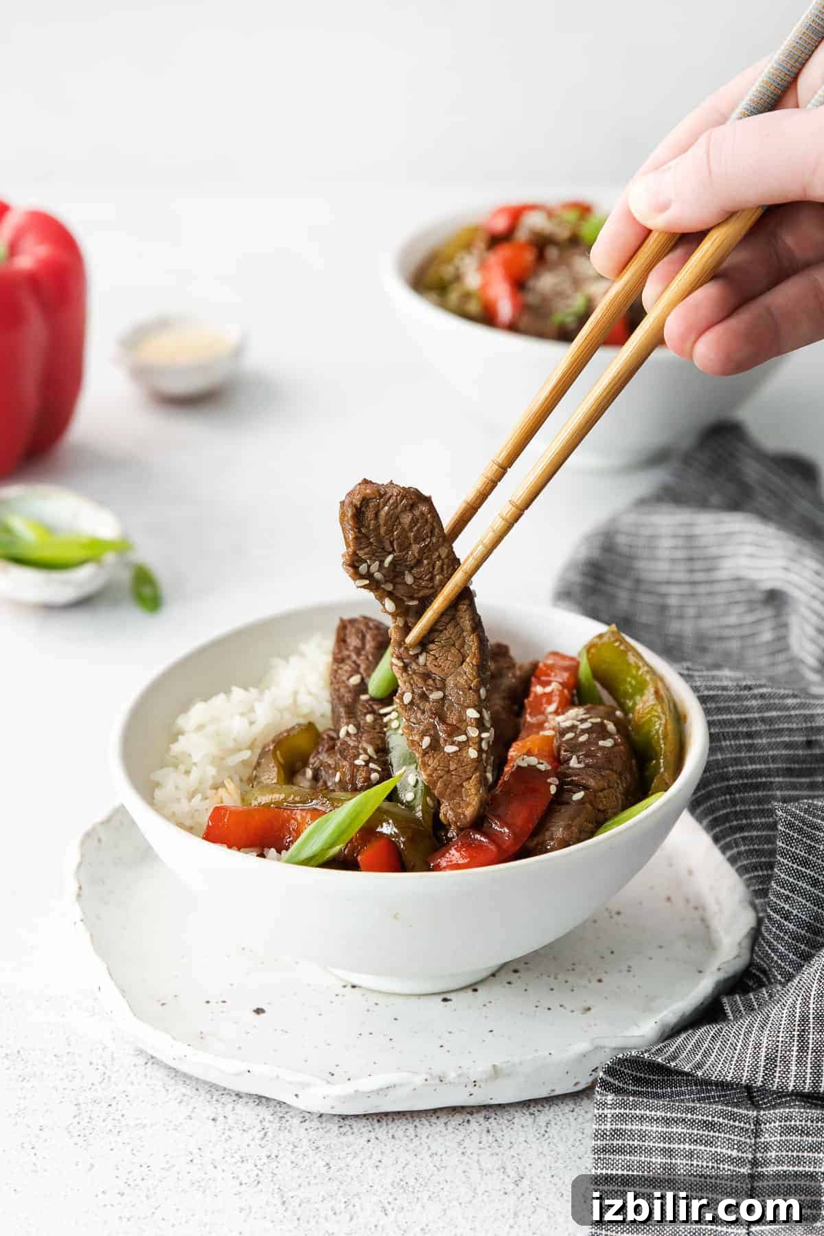 Pepper Steak Recipe: Tender Beef with Bell Peppers 9 Eating pepper steak with chop sticks.