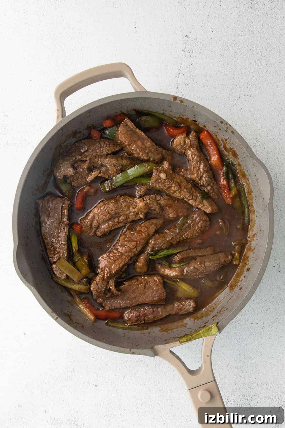 Pepper Steak Recipe: Tender Beef with Bell Peppers 7 Pepper steak cooking in a fry pan.