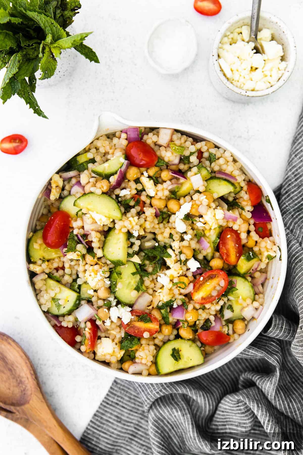 mediterranean couscous salad in a bowl topped with crumbled feta