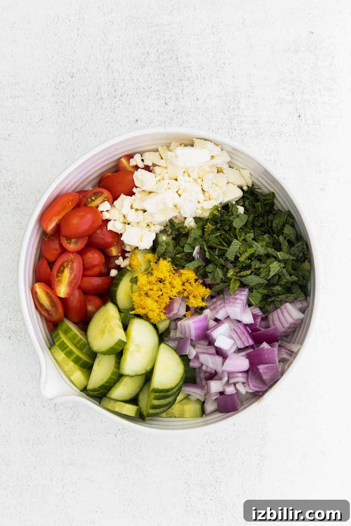 mediterranean cous cous salad ingredients in a bowl