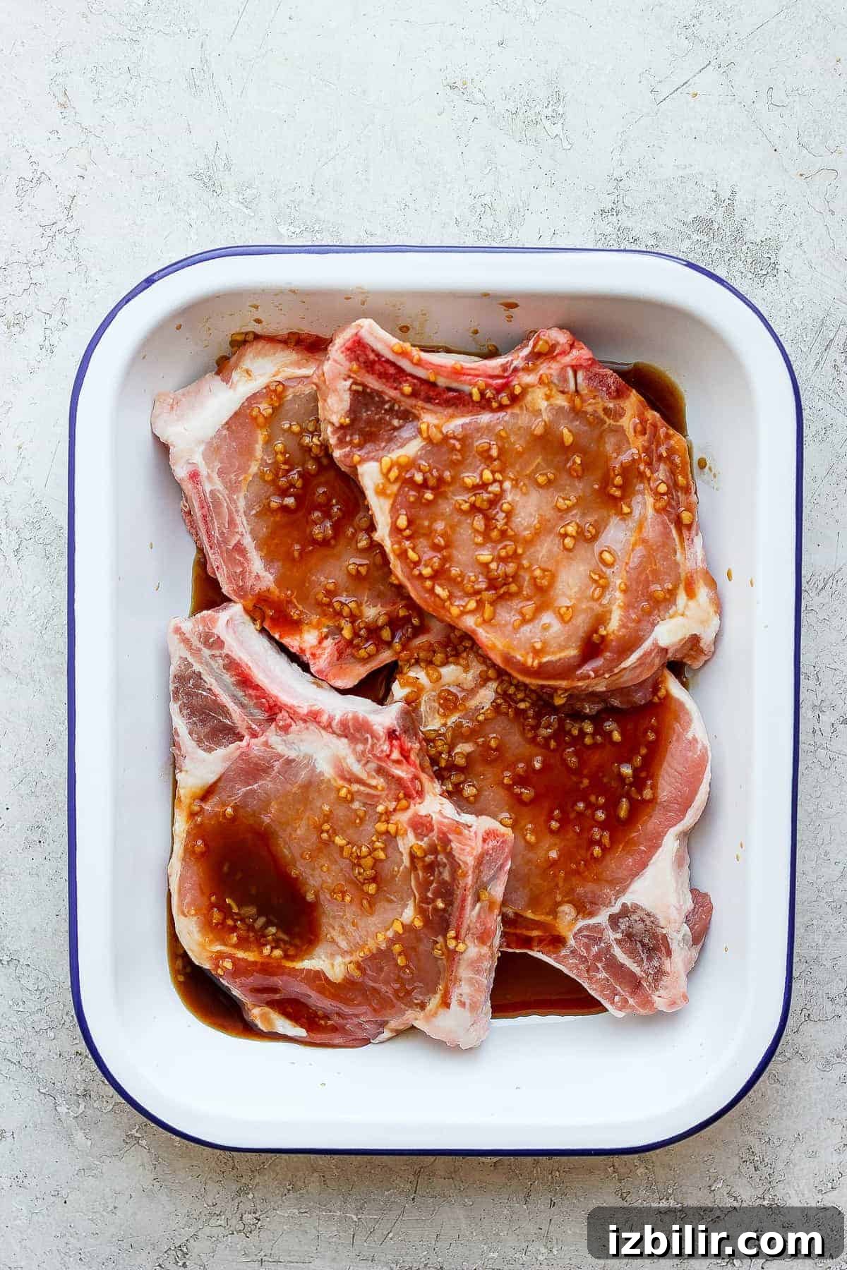 Pork chops marinating in a dish pork chops marinating in dish.