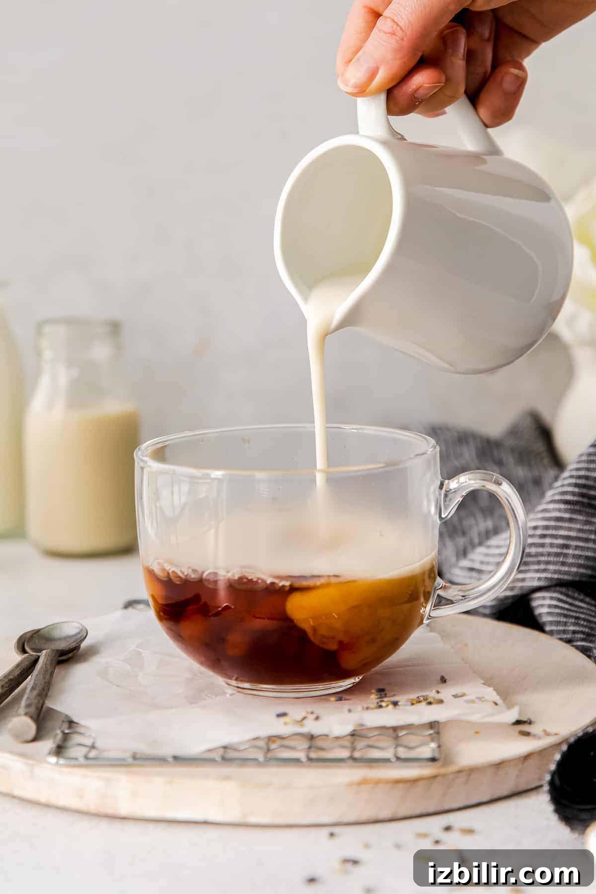 steamed milk being poured in a mug of earl grey tea