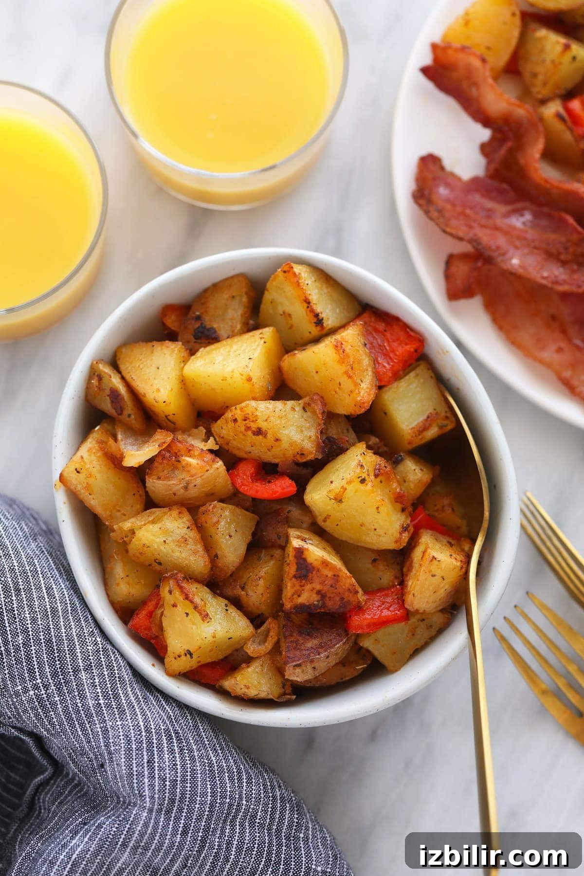 breakfast potatoes in a bowl, served next to a glass of orange juice