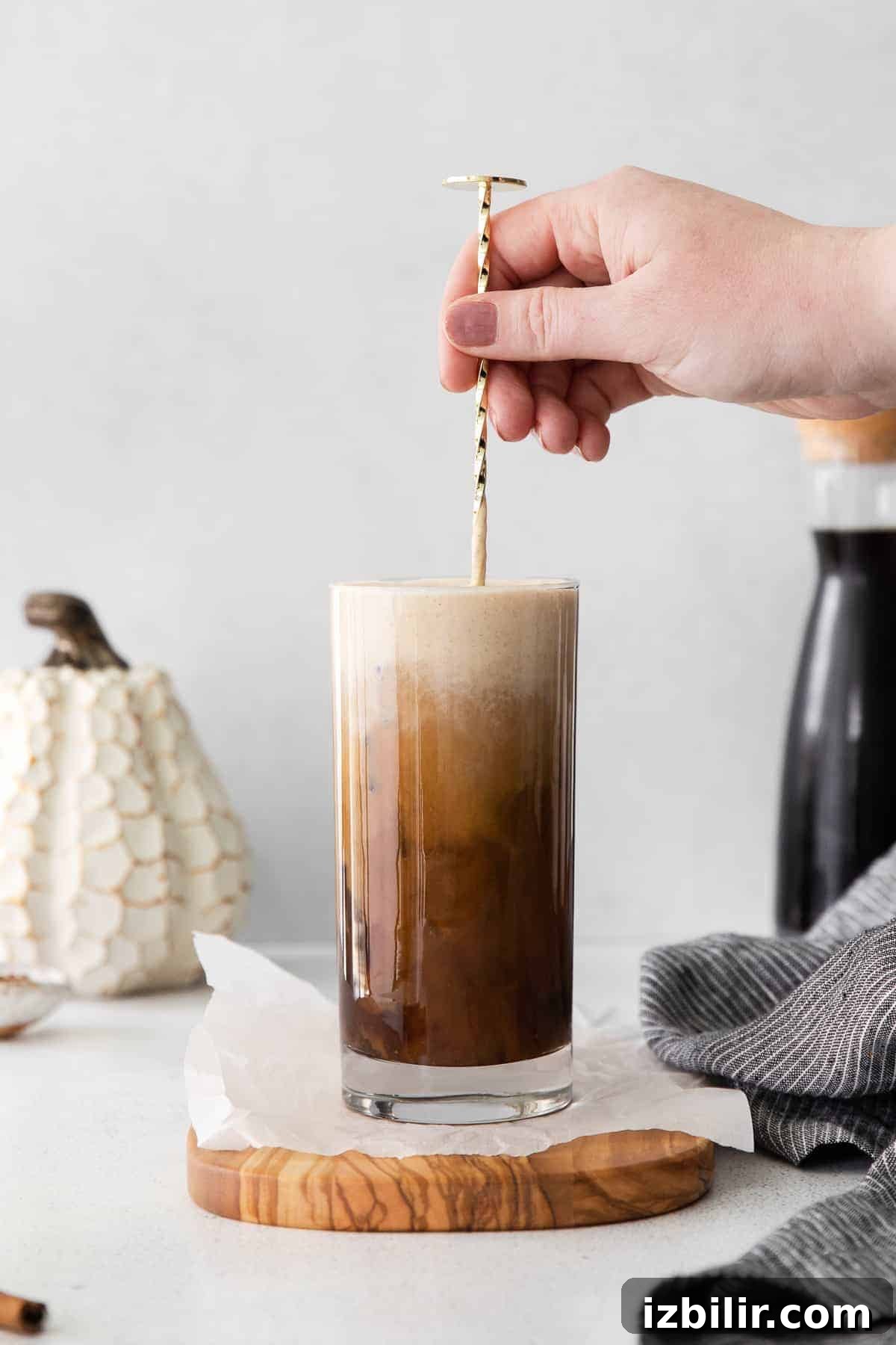 Mixing up Pumpkin Cream Cold Brew with a straw.