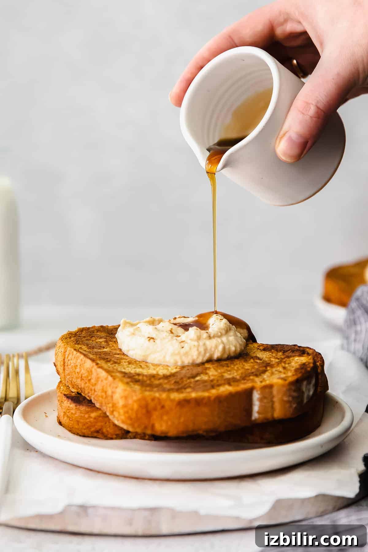 Fluffy Pumpkin French Toast Recipe with Maple Cinnamon Syrup 8 Drizzling maple syrup over the pumpkin french toast.