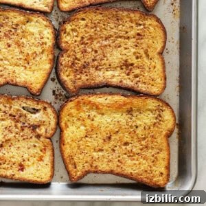 Fluffy Pumpkin French Toast Recipe with Maple Cinnamon Syrup 4 sliced french toast on a baking sheet.