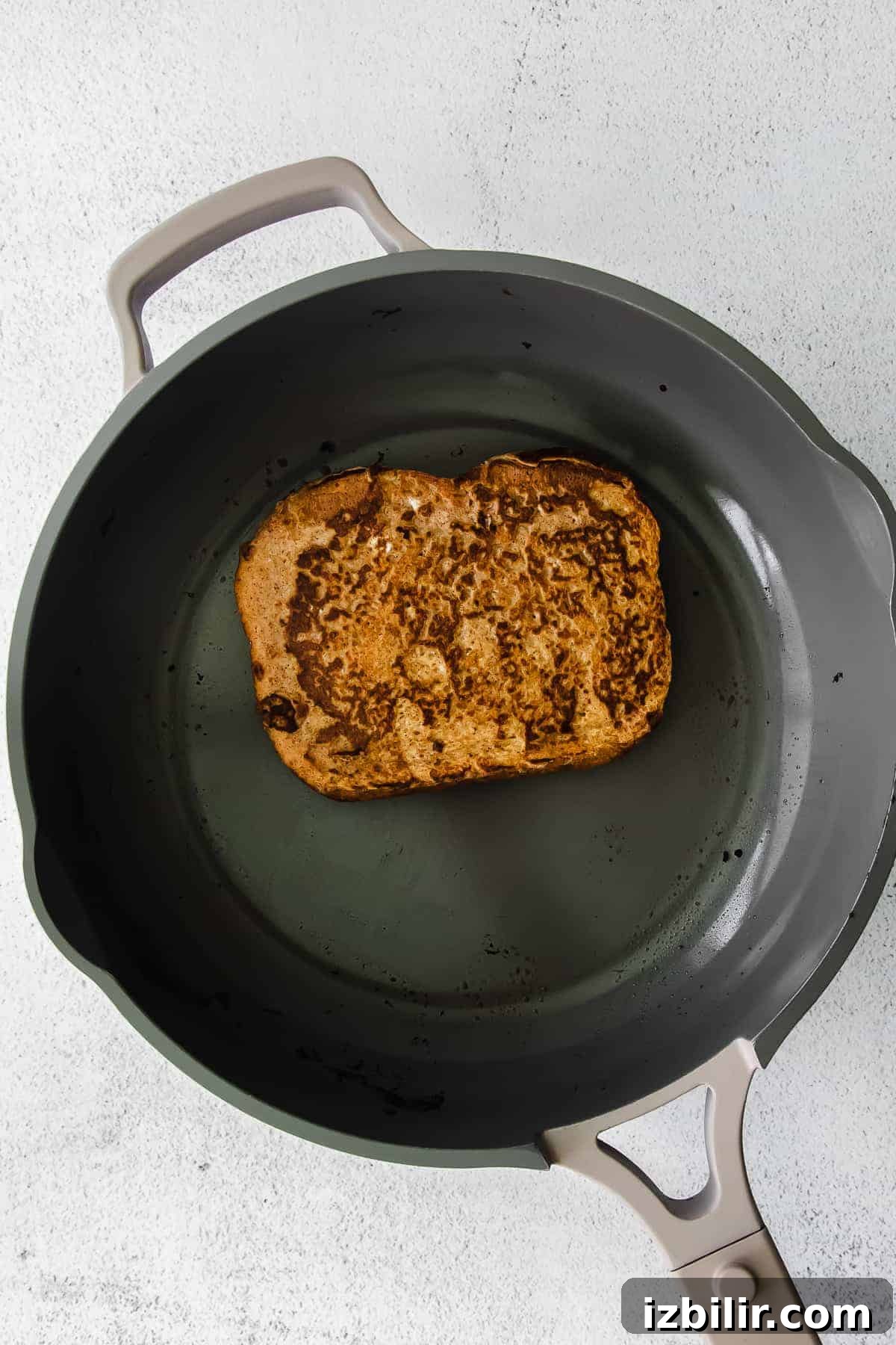 Fluffy Pumpkin French Toast Recipe with Maple Cinnamon Syrup 6 Cooking pumpkin french toast in a skillet pan.
