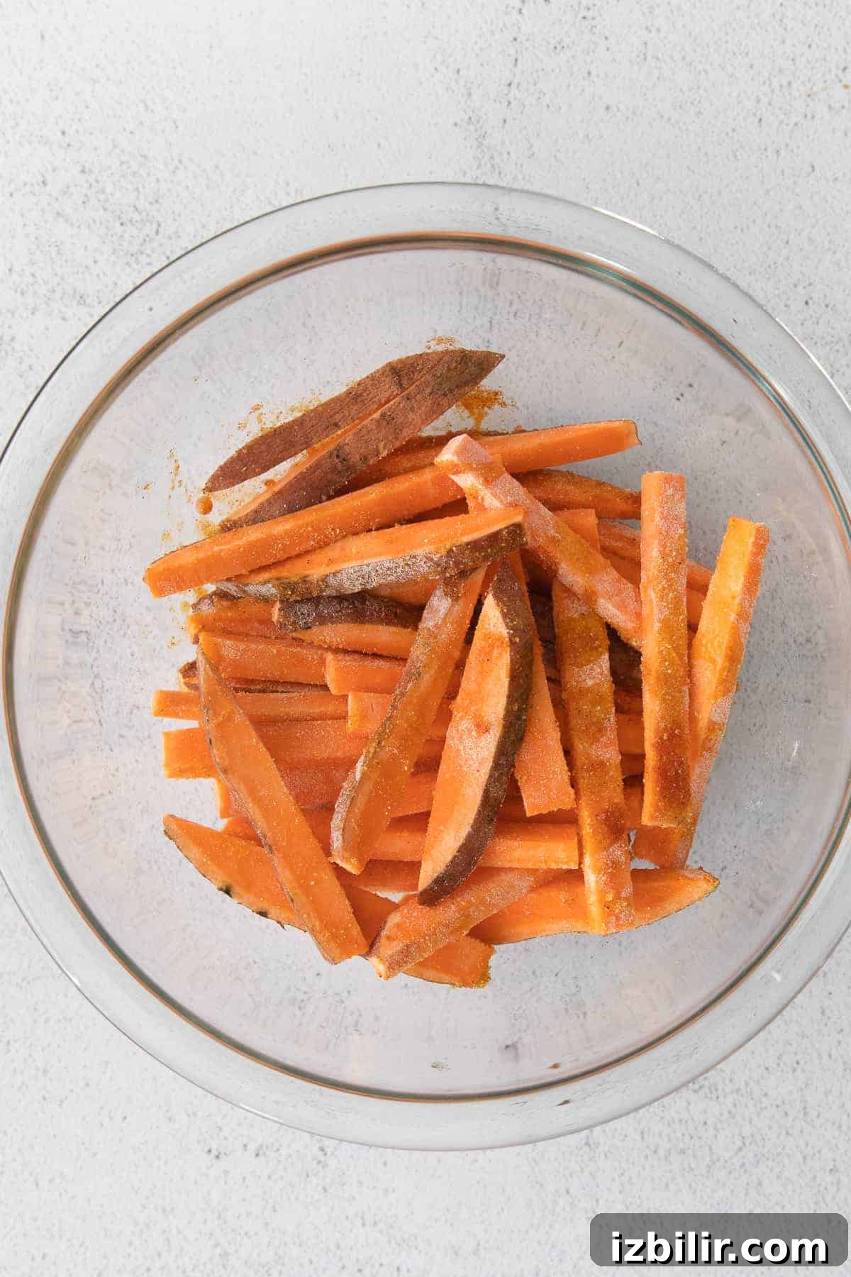air fryer sweet potato fries in a bowl tossed with seasonings